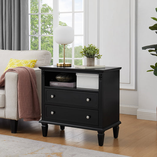 A black 2-drawer farmhouse nightstand with USB ports and a plant on top, placed in a well-lit living room setting.