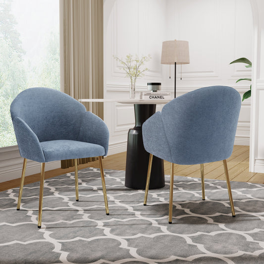 Two modern side chairs with blue upholstery and gold legs, set in a room with a black round table and gold accents.